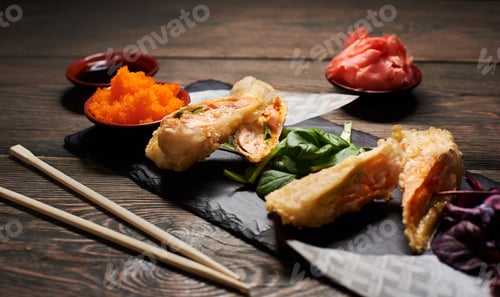 Preview: Serving sushi rolls and other traditional japanese and asian food on a table