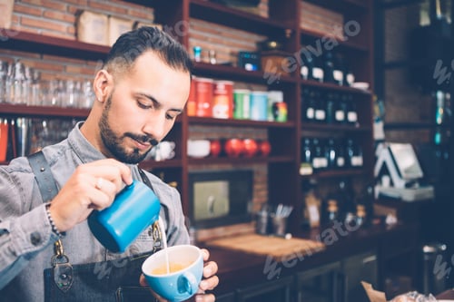 Preview: Barista pouring milk in coffee cup