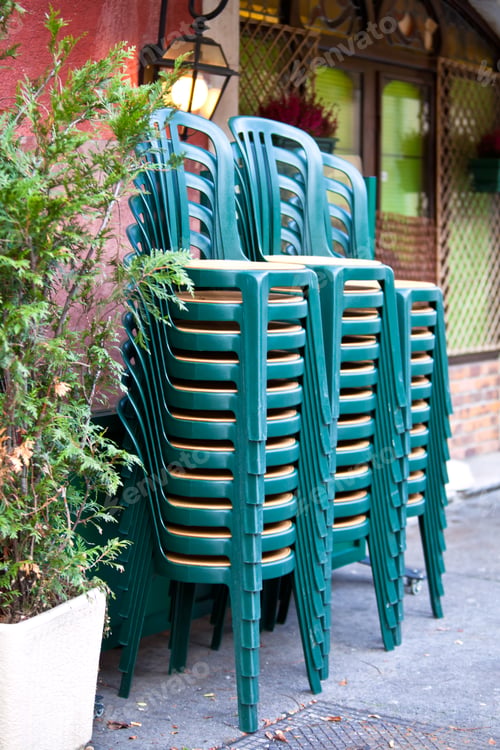 Preview: Stacked green plastic chairs