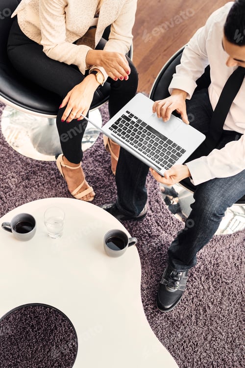 Preview: High angle view of two colleagues working on laptop