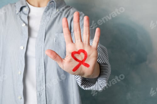 Preview: AIDS awareness sign on male hand against blue background, copy space