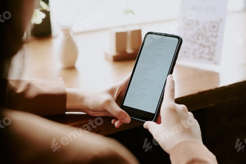 Preview: Checking Smartphone in a Cozy Cafe