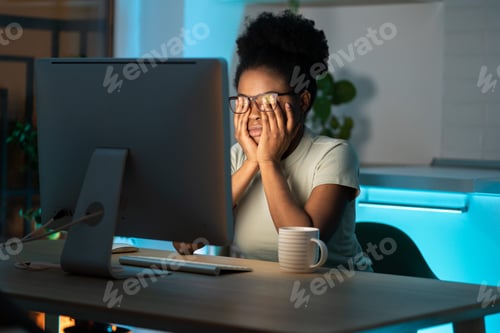 Preview: Overworked african woman freelancer feeling eye strain and fatigue during prolonged computer use