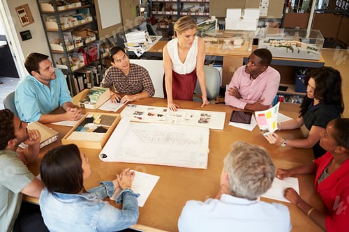 Preview: Female Boss Leading Meeting Of Architects Sitting At Table