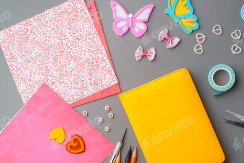 Preview: Crafting supplies arranged for a DIY project on a gray table with scissors, washi tape, and