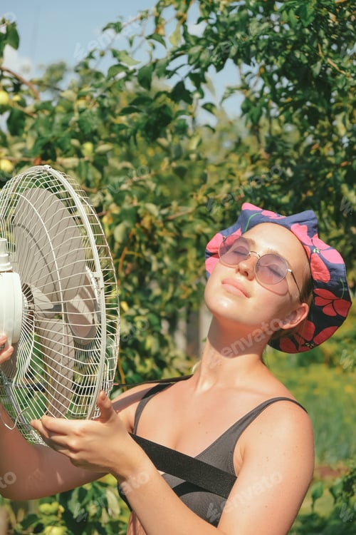 Preview: Heat,abnormal heat,woman cooled by fan mobile fan,heat stroke,heat protection,extreme heat,extreme w