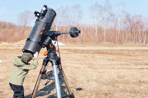 Preview: Child boy near big black telescope on a tripod at the observatory for observation of star and planet