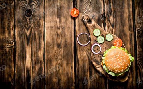 Preview: Hamburger with tomatoes, onions and meat on the Board.