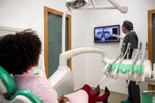 Preview: Dentist showing teeth x ray to patient in dental clinic