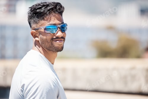 Preview: Fit young male athlete wearing sports sunglasses and smiling while looking at the camera. Mixed rac