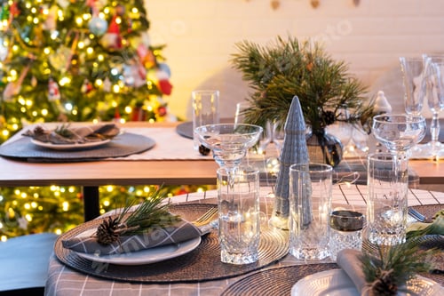 Preview: Serving a festive table with plates, forks, knives, napkins, glasses close-up in the modern interior