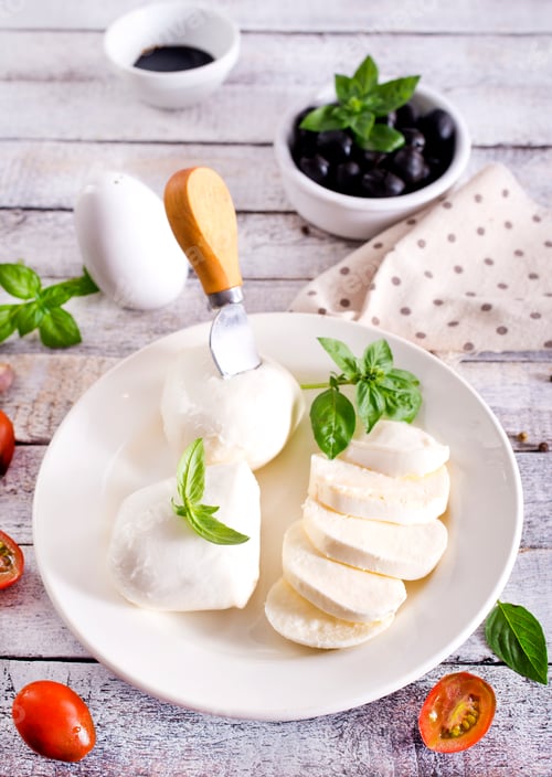 Preview: Large ball of mozzarella on white plate topped with herb oil