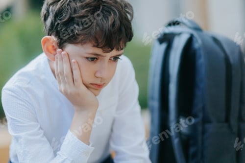 Preview: Exhausted Schoolboy Sitting Alone and Looking Away After a Long School Day