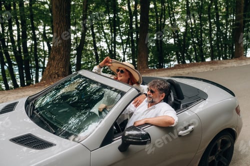 Preview: Feeling good, going for vacation. Senior couple driving convertible cabriolet car