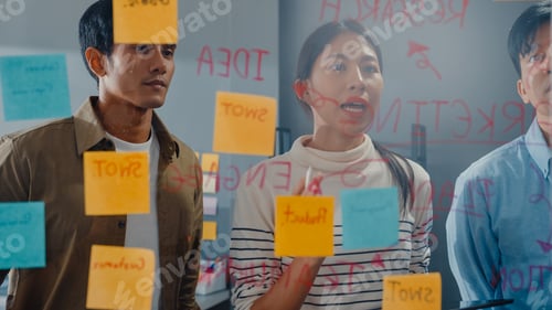 Preview: Asia businesspeople stand behind transparent glass wall listen manager at office.