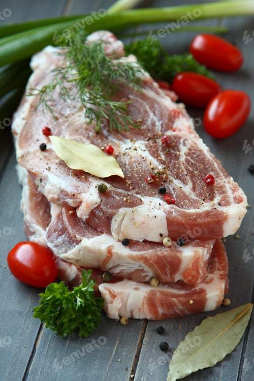 Preview: Fresh raw pork shoulder chop with spices and vegetables