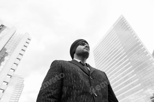 Preview: Young handsome Indian Sikh businessman wearing turban in the city