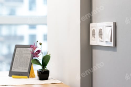 Preview: Group of white european electrical outlets and a switch located on wall