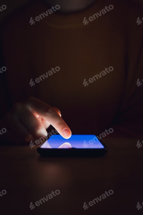 Preview: A woman using smartphone in the dark