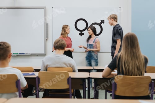 Preview: Young teacher is standing in front of the blackboard during sex education lesson