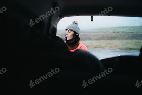 Preview: Woman relaxing in open car trunk countryside