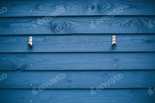 Preview: Close shot of a blue wooden wall with hangers attached to it
