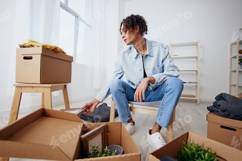 Preview: portrait of a man cardboard boxes in the room unpacking headphones Lifestyle