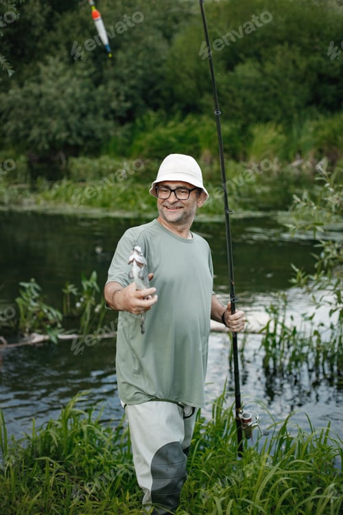 Preview: Fisherman with fishing rod near the lake at summer