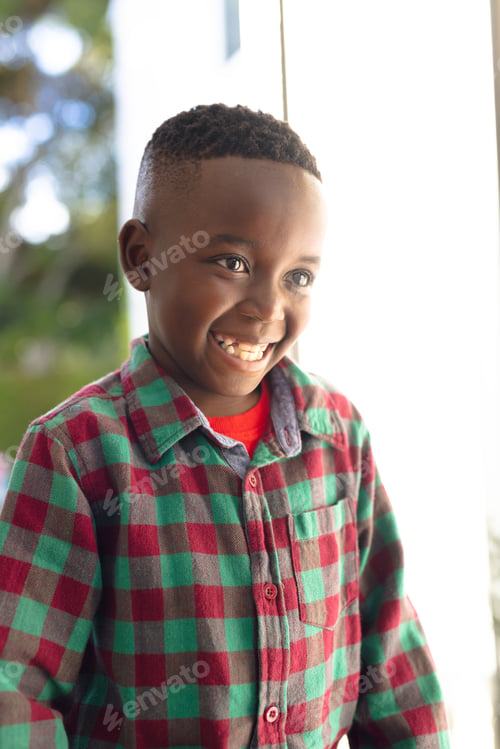 Preview: Vertical picture of happy african american boy welcoming somebody outside the house