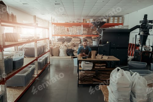 Preview: Business owner of small coffee roasting factory working on his workplace