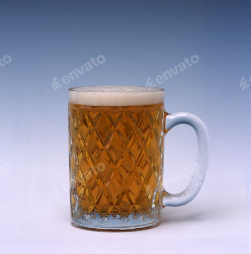 Preview: View of a refreshing beer with foam in a glass with a white and blue background