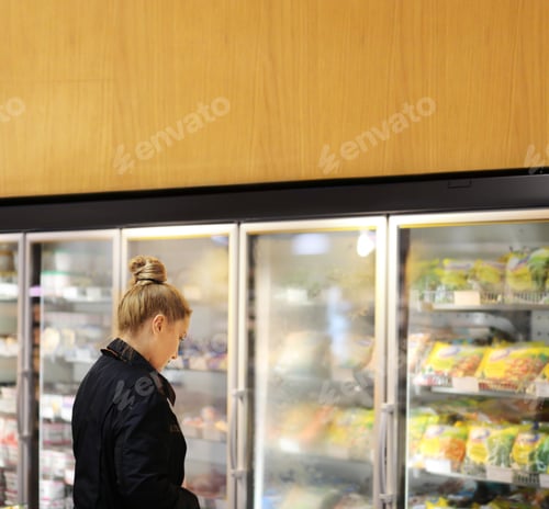 Preview: Woman Choosing Frozen Food From A Supermarket Freezer