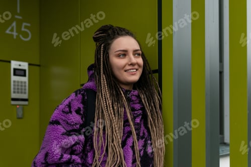 Preview: Stylish informal woman with dreadlocks and piercing wears bun hairstyle