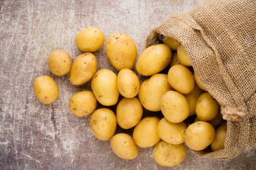 Preview: Sack of fresh raw potatoes on wooden background, top view.
