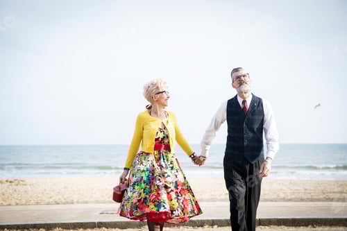 Preview: 1950's vintage style couple holding hands and strolling on beach