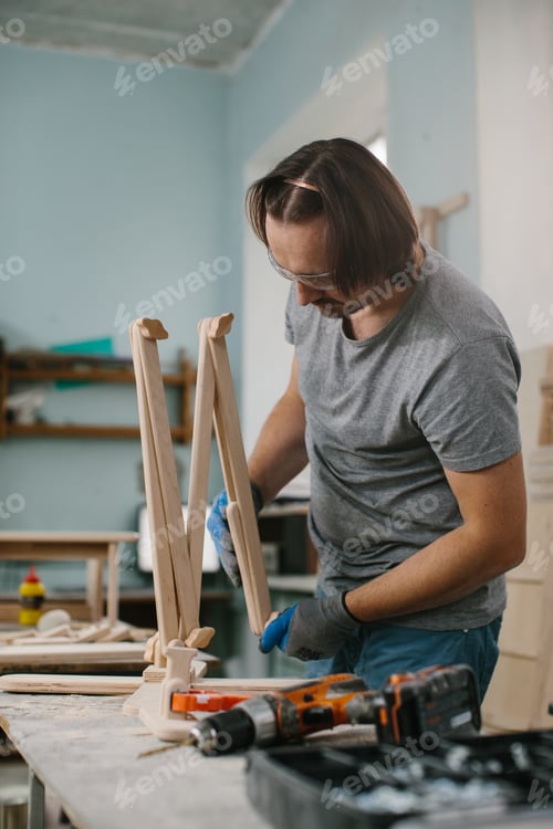 Preview: A carpenter makes wooden toys in a carpentry workshop. Making a bed carousel.