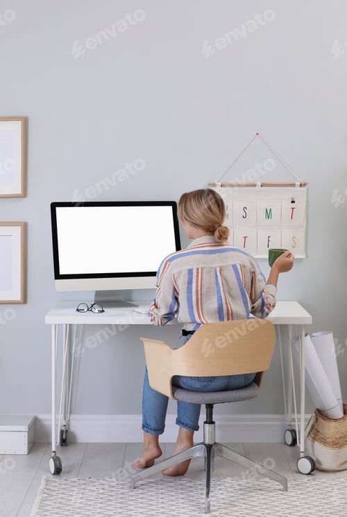 Preview: Young woman working on computer at table in room