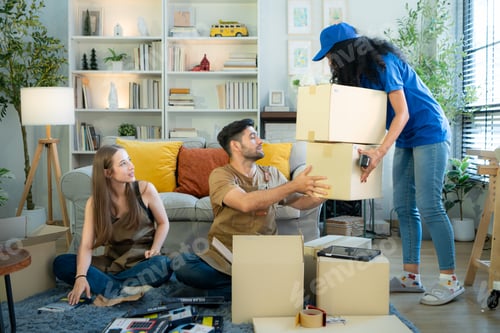 Preview: Delivery young woman takes a cardboard package from the hands of a small business owner