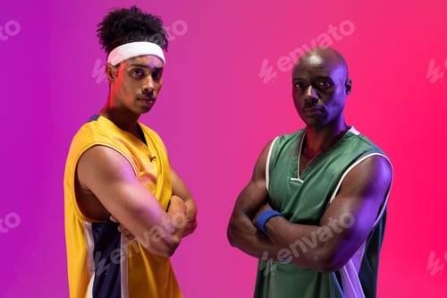 Preview: Image of portrait of two diverse basketball players facing each other on purple to pink background