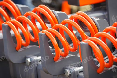 Preview: Hard orange spring made of steel. Part of big industrial or agricultural machine