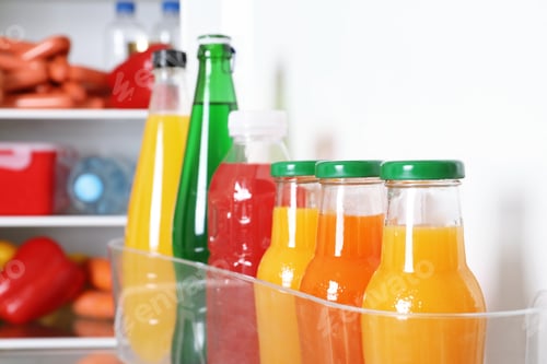 Preview: Bottles of beverages on refrigerator door shelf, closeup