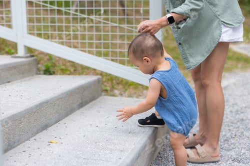 Preview: Baby pulling mother up stone steps outdoors