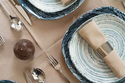 Preview: Details of a stylish table setting with textured ceramic dishes