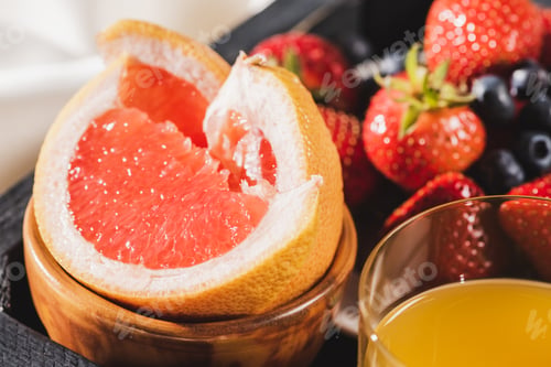Preview: Close up View of French Breakfast With Grapefruit, Orange Juice, Berries on Wooden Tray
