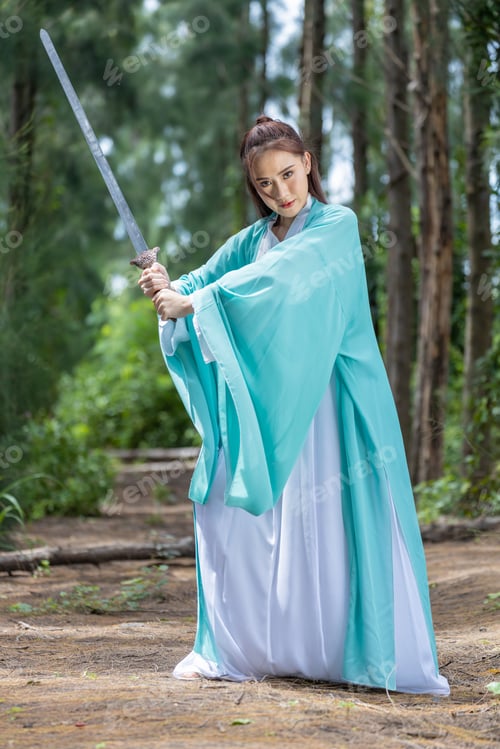 Preview: Young beautiful Asian woman dressed in ancient Chinese warrior style with ancient fan