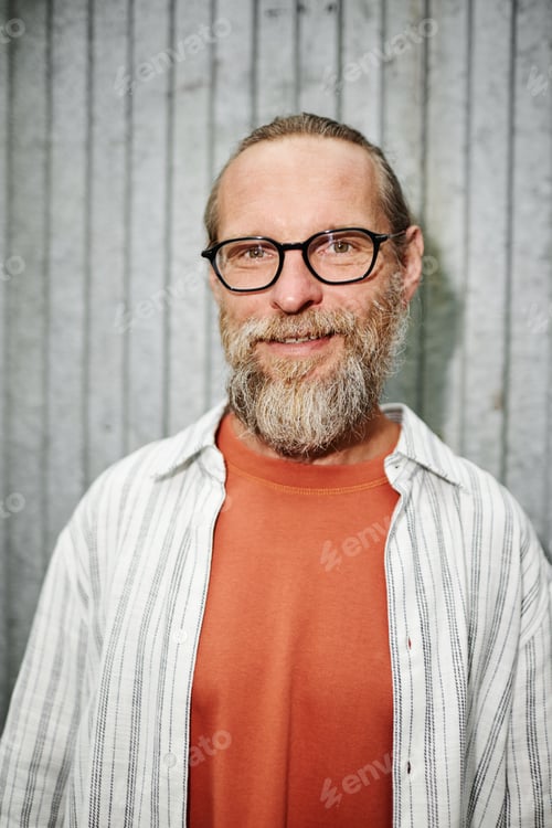 Preview: Smiling Bearded Man in Glasses Shot with Flash Metal Wall Background