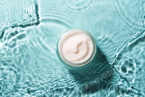 Preview: Cream jar in the water on blue background.