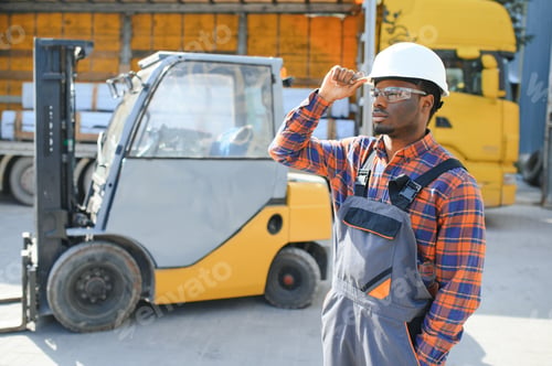 Preview: Portrait of a happy African American male worker driving forklift at workplace