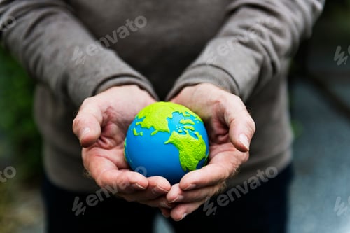 Preview: Hands holding a clay globe planet Earth