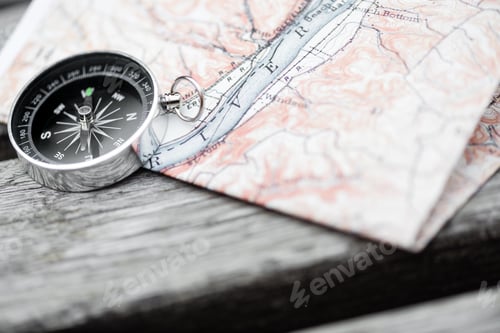 Preview: Compass and map on a beautiful wooden surface. Top view